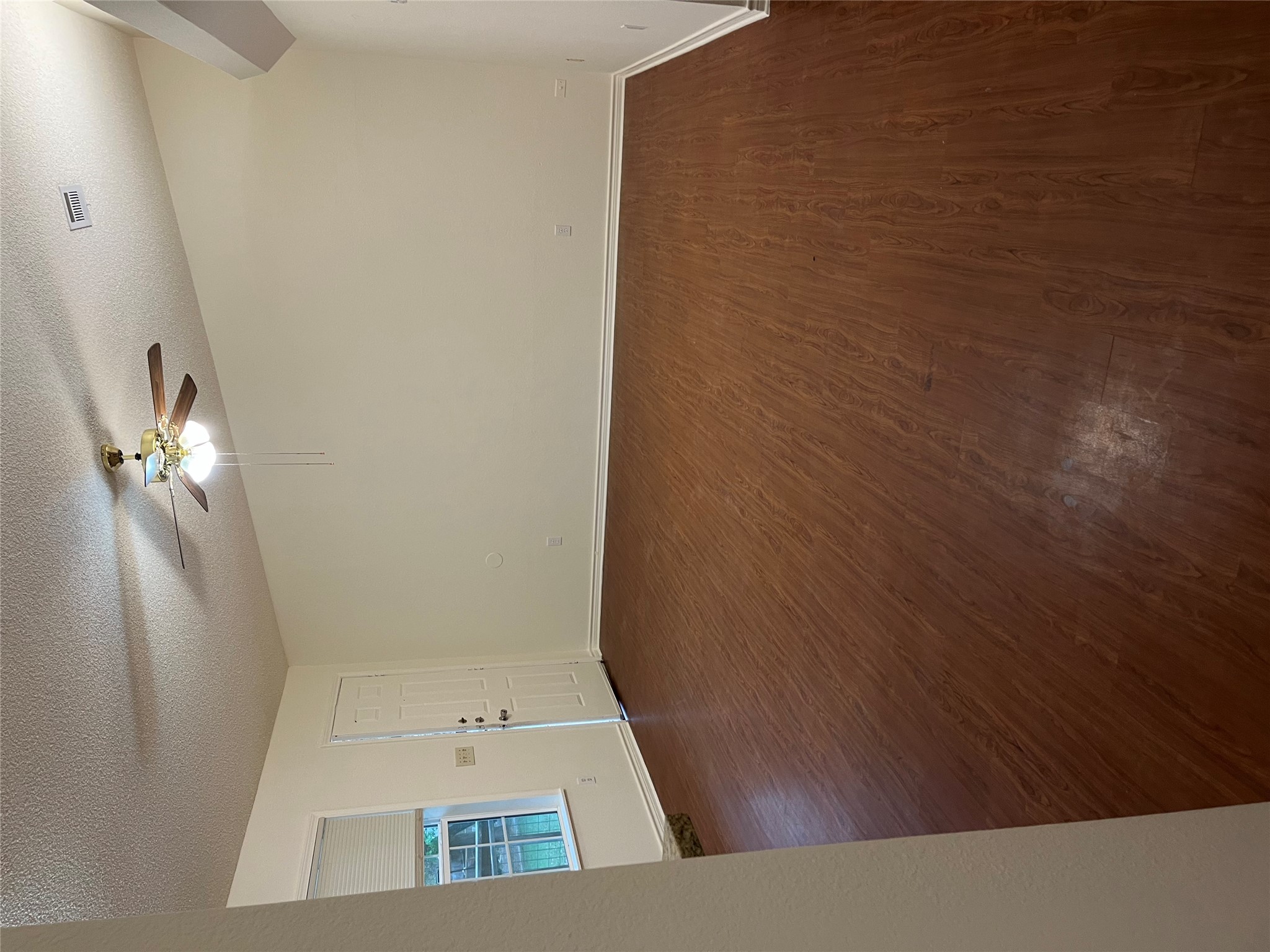 23393 Nameless Road, Unit 144 Leander, TX 78641 - Photo 3 of 23 Empty room with dark wood-style floors, visible vents, ceiling fan, and a textured ceiling