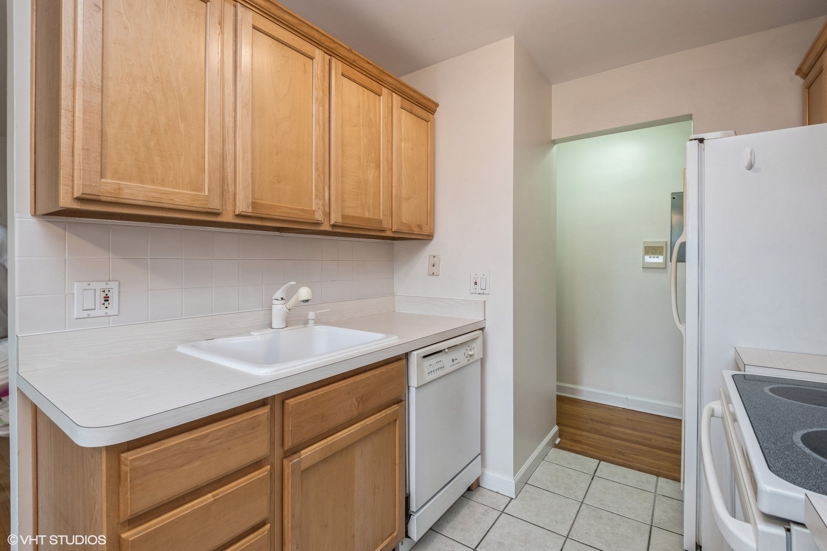 820 Seward Street, Unit 3E Evanston, IL 60202 - Photo 7 of 24 a kitchen with a sink cabinets and a refrigerator