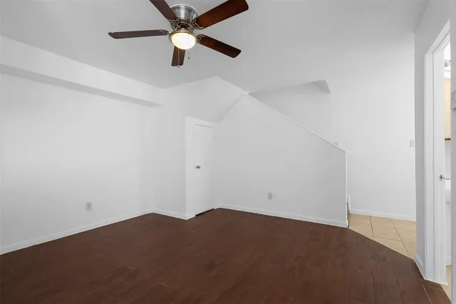 an empty room with a ceiling fan and a window