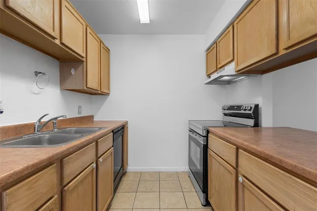 a kitchen with stainless steel appliances granite countertop a sink stove and cabinets