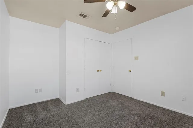 an empty room with a chandelier fan