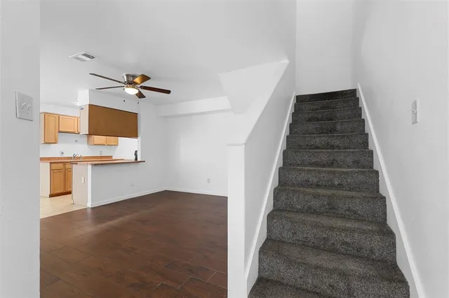 a view of a hallway with stairs and wooden floor