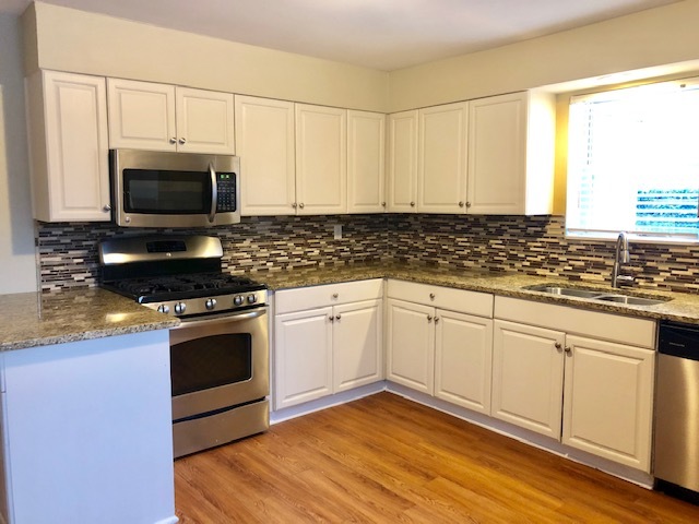 40 Valley Road Glen Ellyn, IL 60137 - Photo 16 of 24 a kitchen with granite countertop a stove a sink and a microwave