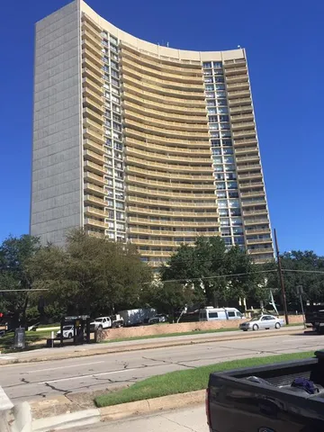 a view of a building and car parked on the side of road