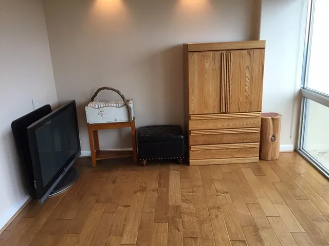 a view of a livingroom with wooden floor and cabinet