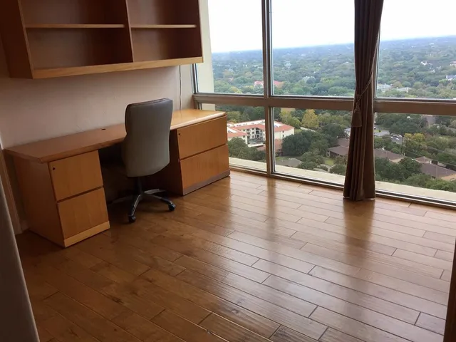 a workspace with wooden floor and a floor to ceiling window