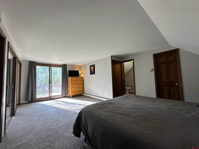 a bedroom with a bed and a large window