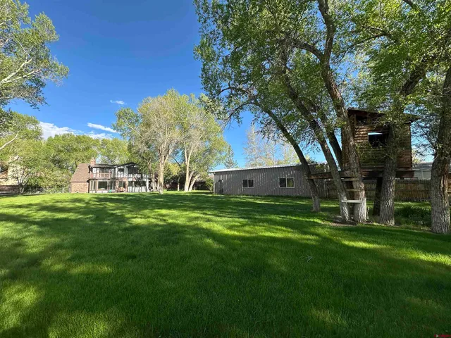 a front view of houses with yard and green space