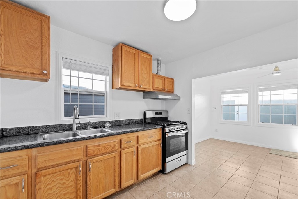 1104 Williamson Avenue Fullerton, CA 92833 - Photo 73 of 75 a kitchen with granite countertop a stove a sink and a white cabinets