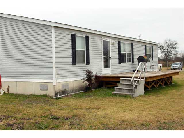 775 Homann Road Lockhart, TX 78644 - Photo 1 of 1 a backyard of a house with wooden deck and outdoor seating