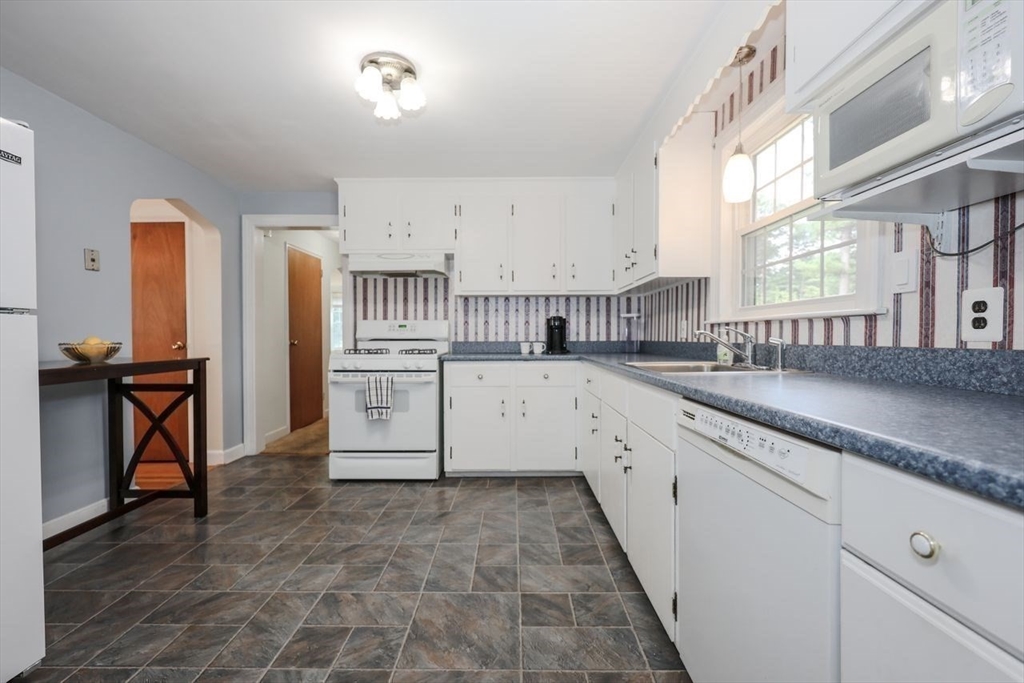 35 Walnut Road Chelmsford, MA 01824 - Photo 5 of 42 a large white kitchen with granite countertop a sink a stove a washer and dryer