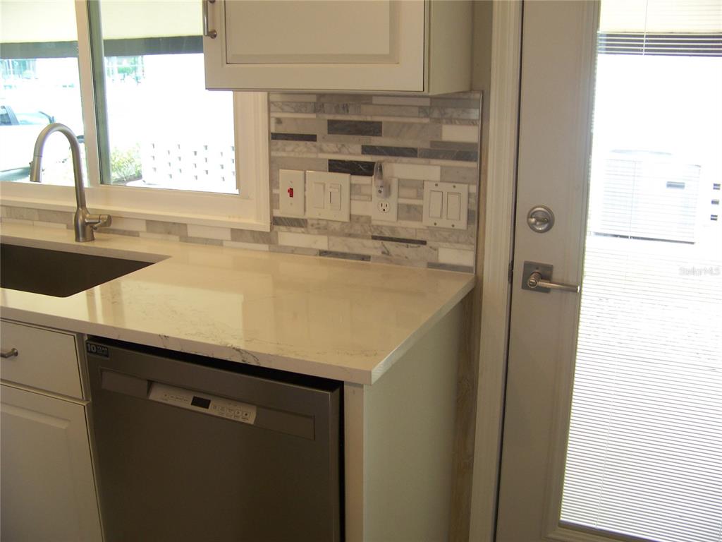 15550 Burnt Store Road, Unit 202 Punta Gorda, FL 33955 - Photo 16 of 61 a kitchen with a sink a window and a refrigerator