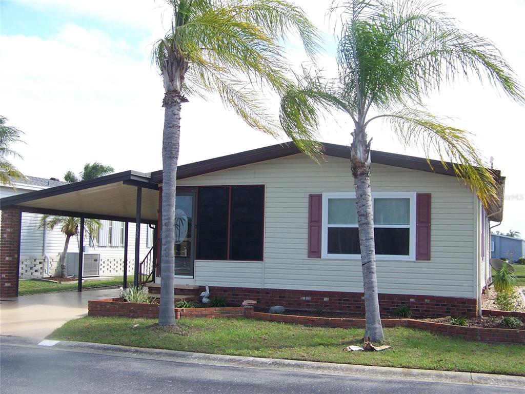 15550 Burnt Store Road, Unit 202 Punta Gorda, FL 33955 - Photo 2 of 61 a front view of a house with a garden
