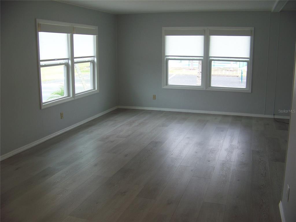 15550 Burnt Store Road, Unit 202 Punta Gorda, FL 33955 - Photo 28 of 61 an empty room with wooden floor and windows