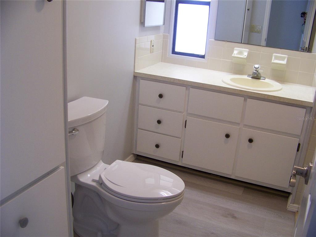 15550 Burnt Store Road, Unit 202 Punta Gorda, FL 33955 - Photo 33 of 61 a bathroom with a sink a toilet and mirror