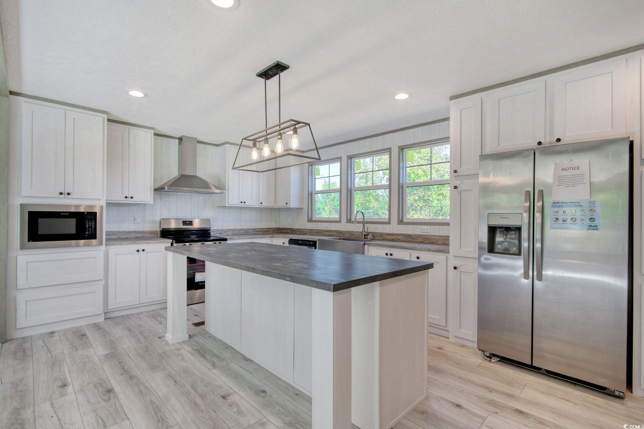 280 Samuel Road Loris, SC 29569 - Photo 6 of 29 Kitchen with a kitchen island, wall chimney exhaus