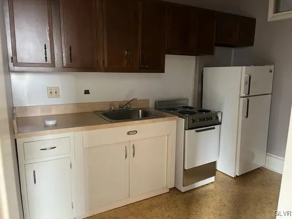 a kitchen with appliances a refrigerator and cabinets