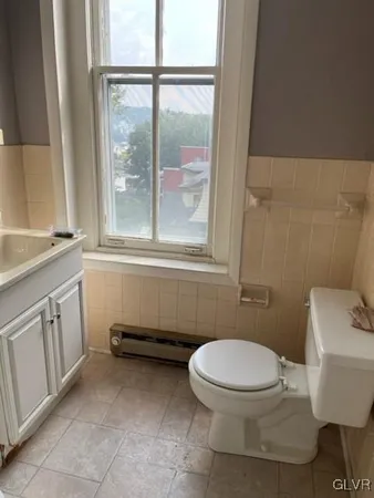 a bathroom with a toilet a sink and a window