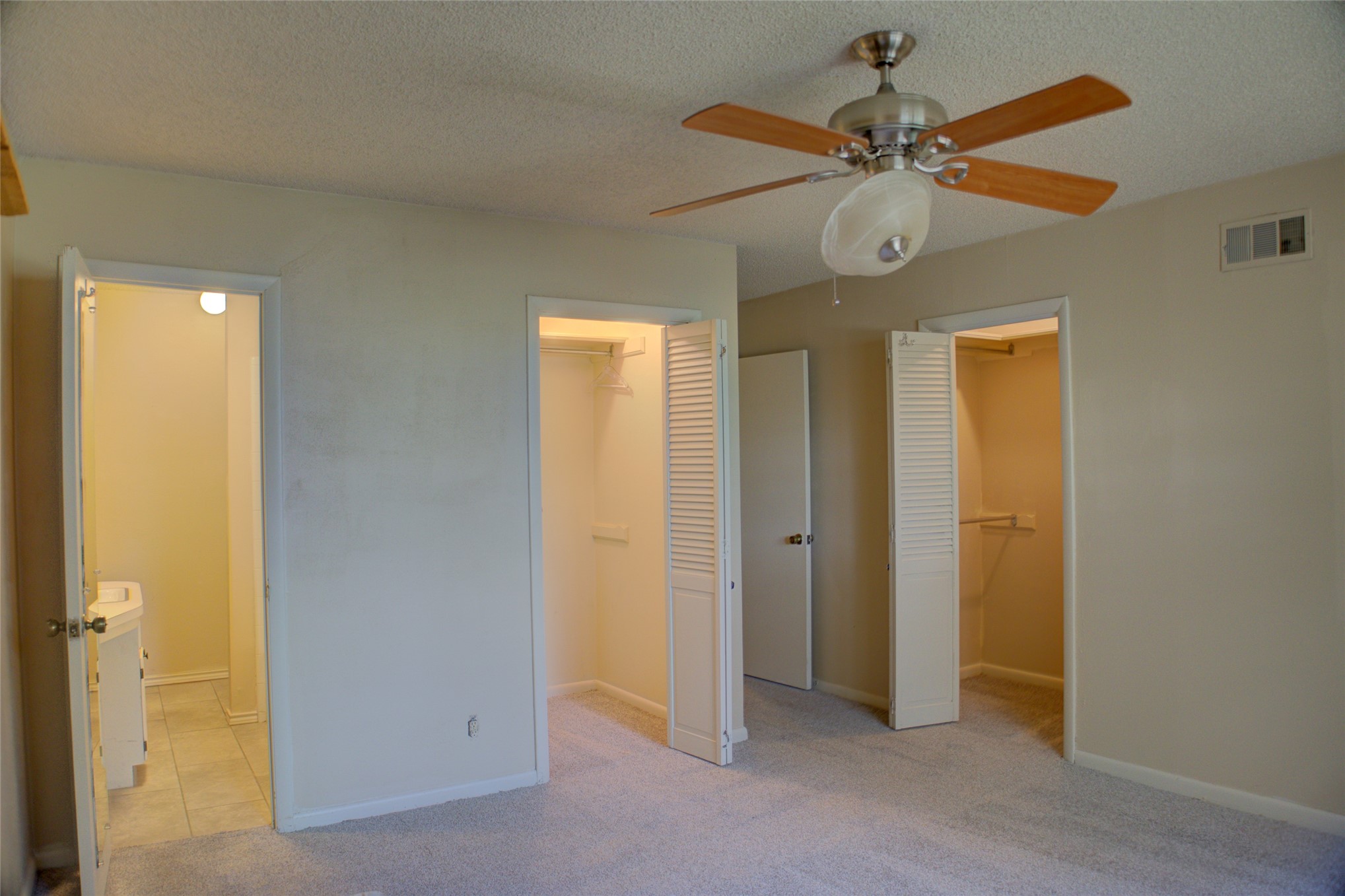 12420 South Garnett Road Broken Arrow, OK 74011 - Photo 33 of 44 Light-colored carpeted flooring, two wardrobe closets with bi-fold louvered doors, and a ceiling fan with light fixture