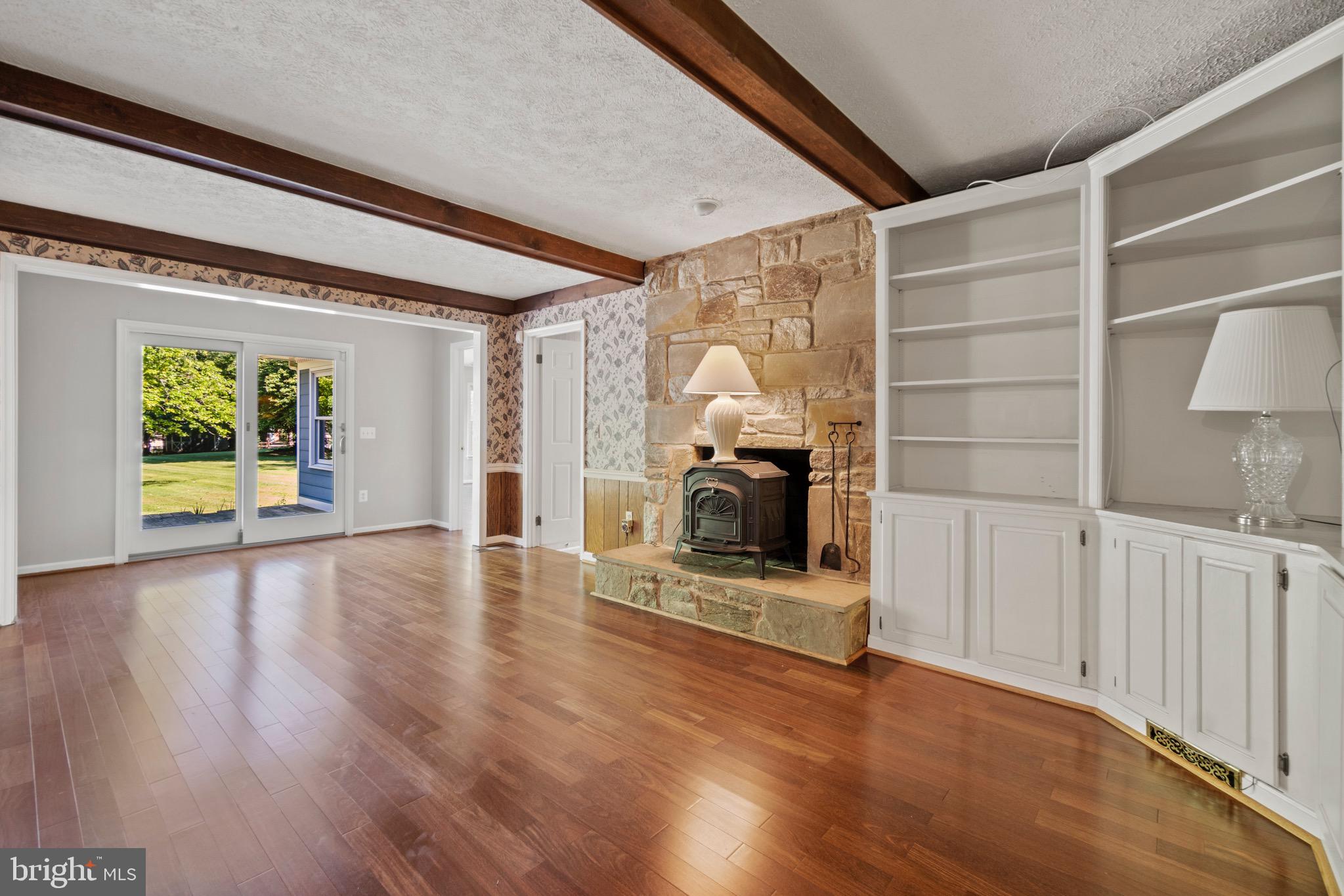 7409 Warfield Road Gaithersburg, MD 20882 - Photo 3 of 22 a view of a livingroom with wooden floor a fireplace and window