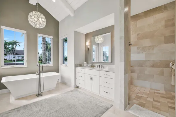 a spacious bathroom with a double vanity sink a mirror and a bathtub
