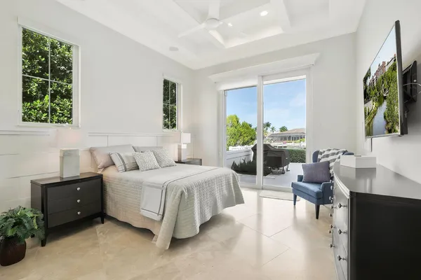 a spacious bedroom with a bed and a flat screen tv