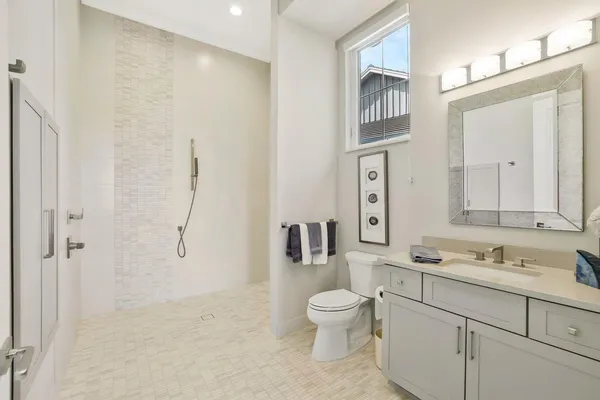 a bathroom with a toilet sink a mirror and shower