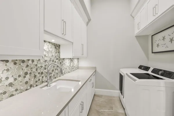 a bathroom with a sink and a stove with white countertops