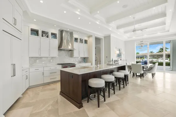 a large kitchen with kitchen island a sink table and chairs