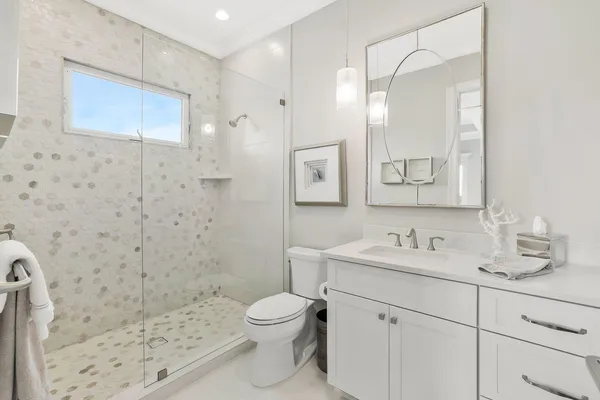 a bathroom with a sink a toilet and shower