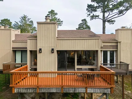 a view of a house with wooden deck and furniture