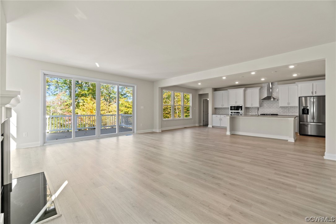 12812 Lonan Avenue Chesterfield, VA 23838 - Photo 14 of 49 a view of an empty room with wooden floor and a kitchen