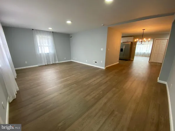 an empty room with wooden floor and a window