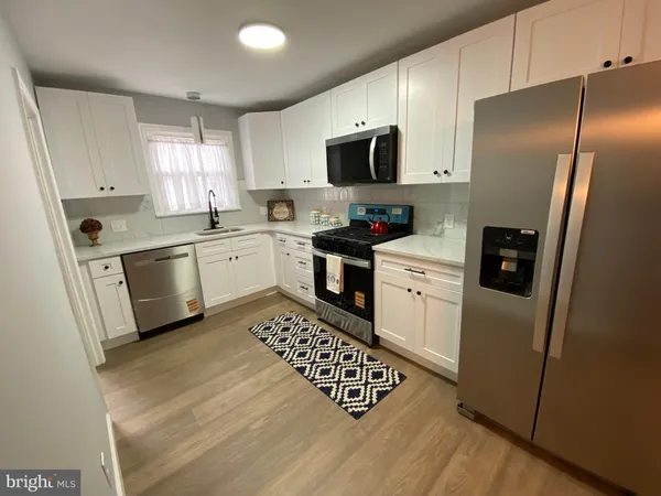 a kitchen with a sink a refrigerator a microwave and cabinets