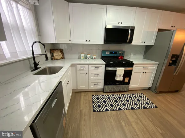 a kitchen with a sink a stove and cabinets