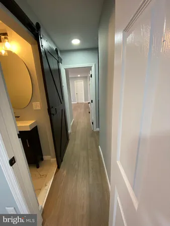 a view of a hallway with wooden floor and entryway