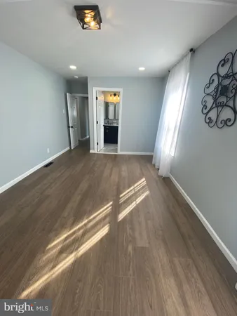 an empty room with windows and fireplace