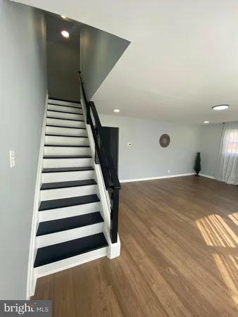 a view of a livingroom with wooden floor and stairs