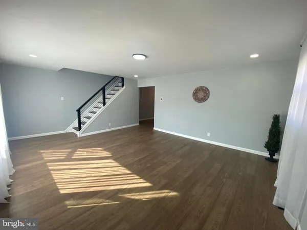 an empty room with wooden floor and stairs