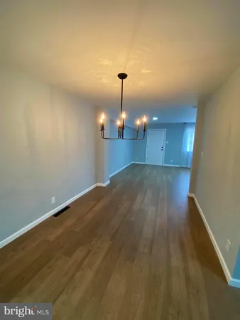 a view of a room with wooden floor and ceiling fan