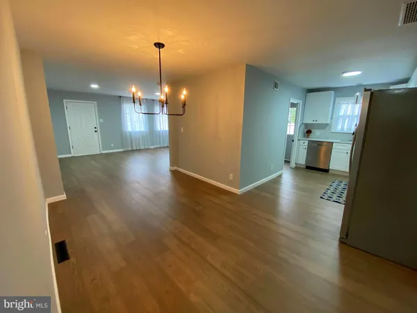 a view of a kitchen with a sink and dishwasher a refrigerator with wooden floor