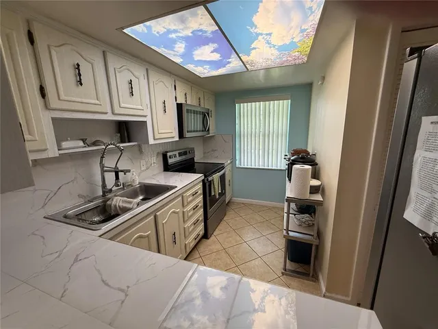 a kitchen that has a sink cabinets counter space and appliances