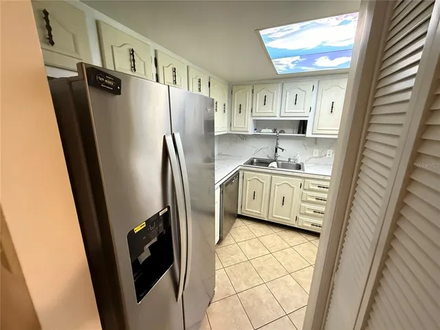 a kitchen with a refrigerator a sink and cabinets