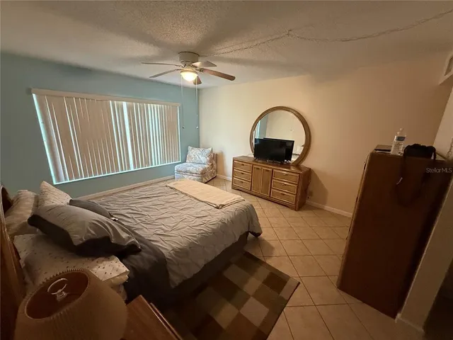 a bedroom with a bed and a dresser next to a window
