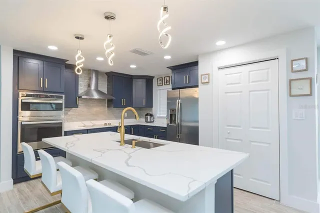 a kitchen with kitchen island a sink appliances and cabinets