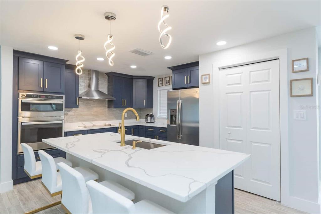 1613 Druid Road Clearwater, FL 33756 - Photo 11 of 47 a kitchen with kitchen island a sink appliances and cabinets