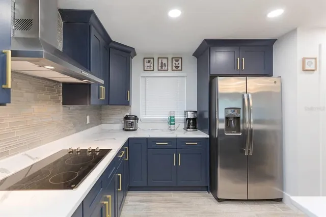 a kitchen with stainless steel appliances granite countertop a sink a stove and a refrigerator