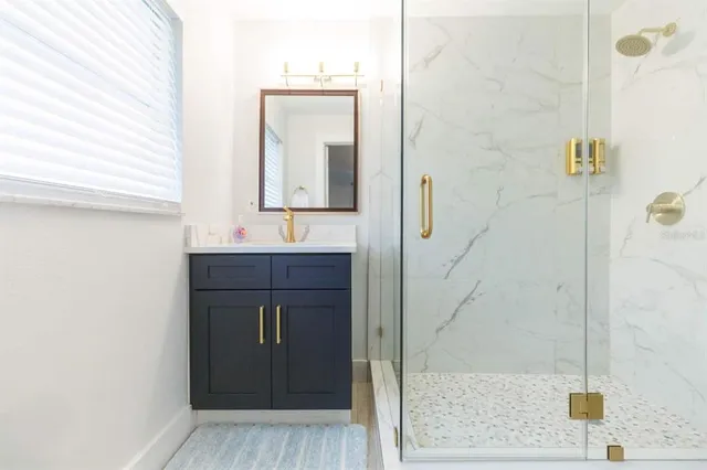 a bathroom with a sink a mirror and shower