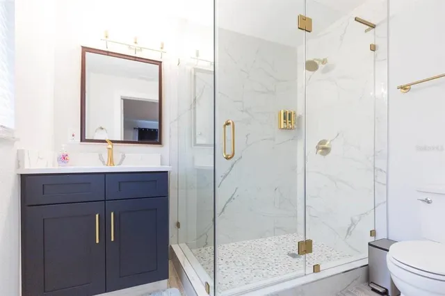 a bathroom with a bathtub shower sink mirror and toilet
