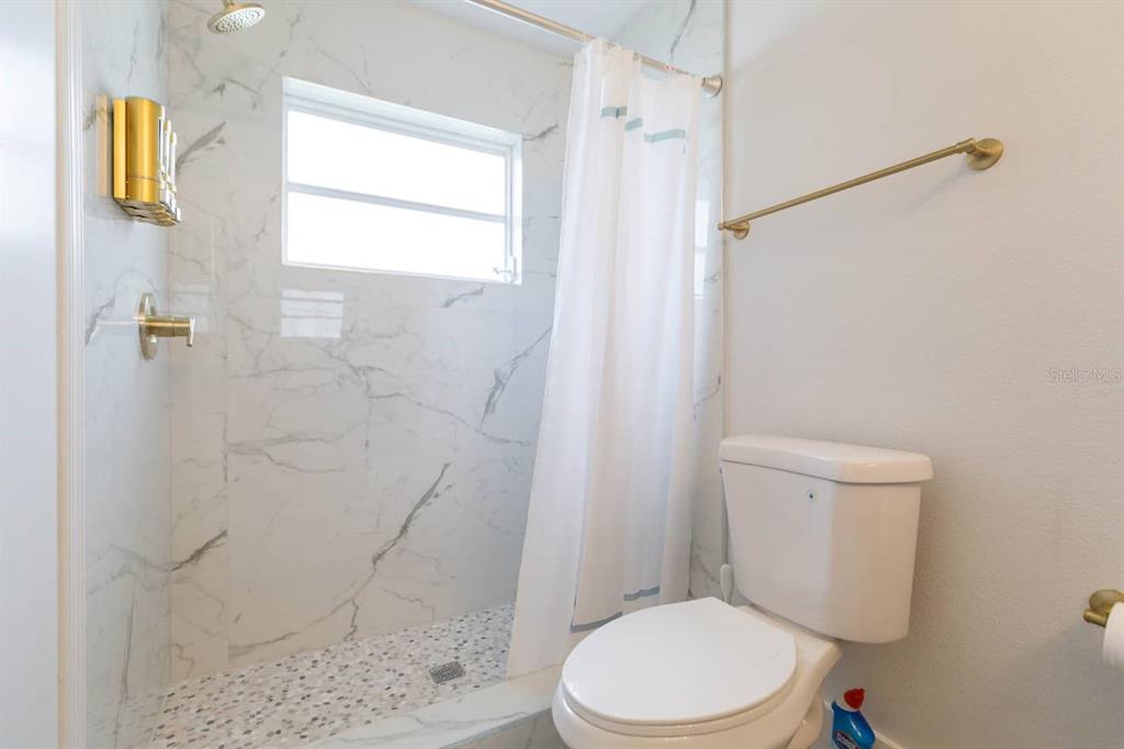 1613 Druid Road Clearwater, FL 33756 - Photo 25 of 47 a white toilet sitting next to a shower